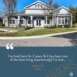 a building with grass trees and a review