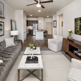 Living Room Spacious and well lit living room with wood floors and a large window with access to the kitchen